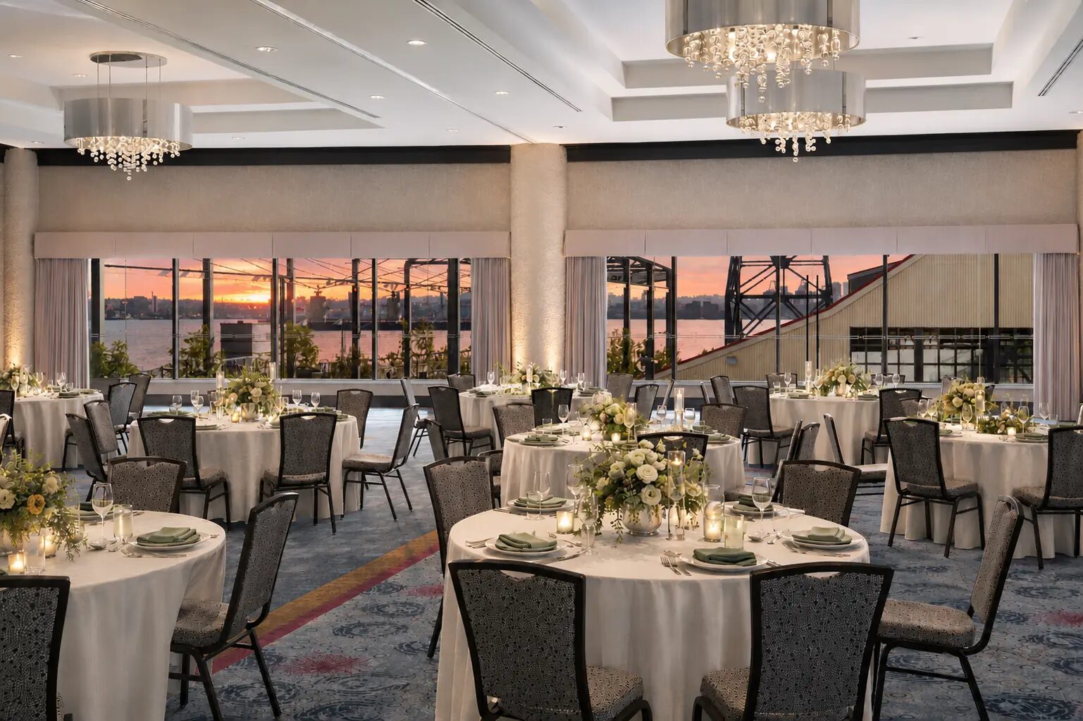 Pinnacle Ballroom set with round banquet tables at sunset with waterfront views